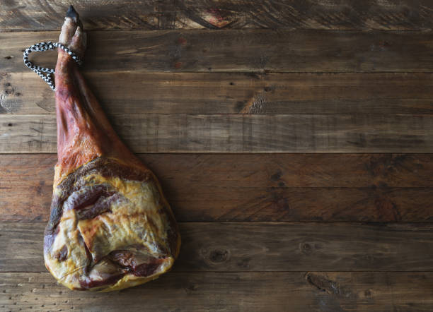 istock Cured pork shoulder on a rustic wooden base. Copy space. Cured pork leg. 1356034168