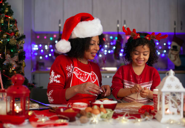 istock African-American mother and daughter having fun while making Christmas cookies. 1356035268