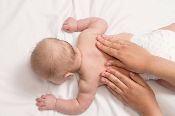 istock baby massage, close-up hands on baby back 1356035621
