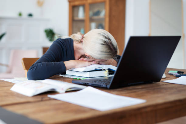 istock Female student preparing for exams and has her head resting on books. 1356035645