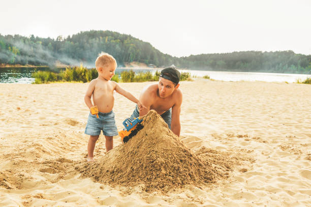 istock Dad and son play with sand 1356040796
