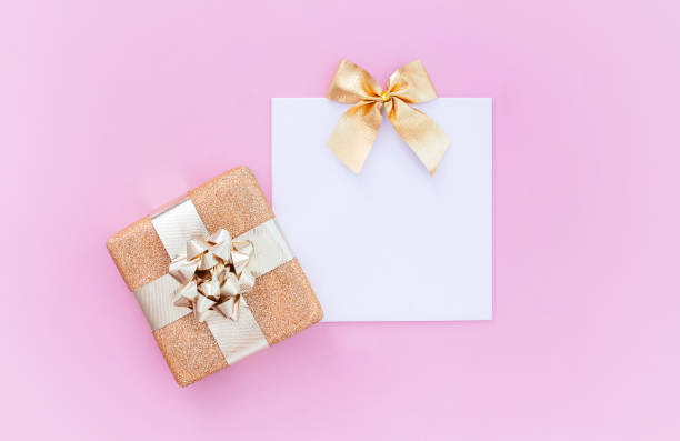 istock blank blank card with gift and on pastel pink background with place for text 1356048322