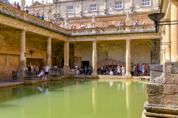 Pool and balconies in the Roman Baths in Bath Bath, England - July 2019: People visiting the Roman Baths in the centre of Bath roman baths stock pictures, royalty-free photos & images