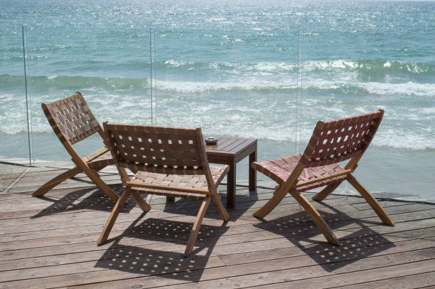 istock Table and three wicker chairs by the sea close up 1356052698