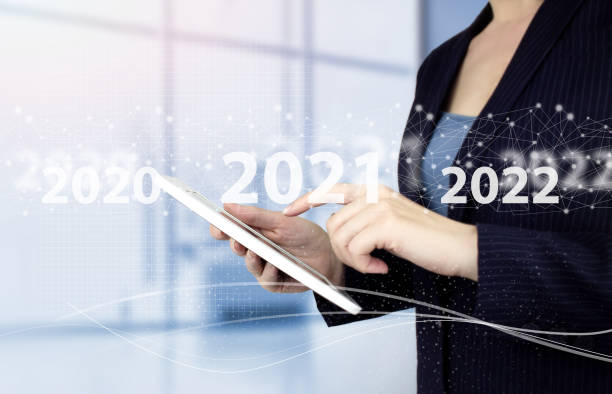 istock Loading year 2021 to 2022. Start concept. Hand touch white tablet with digital hologram 2021 sign on light blurred background. Welcome year 2022. Business new year card concept 1356053585