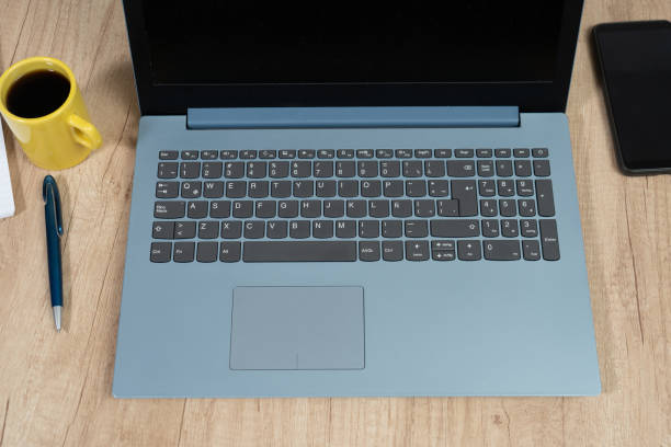 a spanish version laptop keyboard next to a coffee and a pen. technology concept, homeoffice - printer top view imagens e fotografias de stock