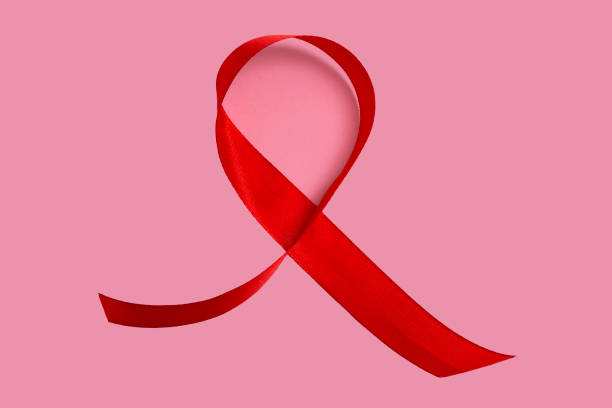 istock Red AIDS awareness ribbon on pink background. Close up, copy space 1356055161