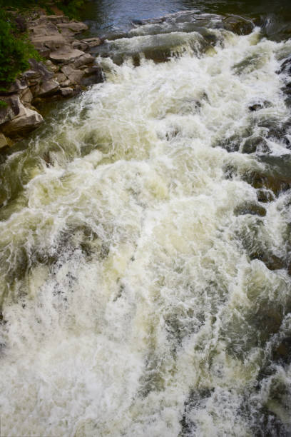 istock A stormy stream of a mountain river with a waterfall flows between the rocky banks 1356055819