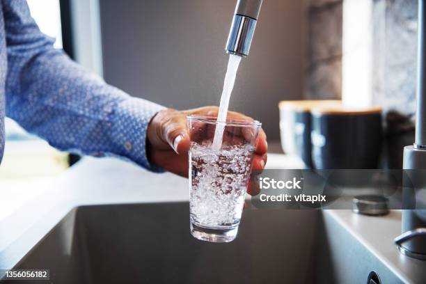 Man Pouring Himself Water Stock Photo - Download Image Now - Water, Faucet, Drinking
