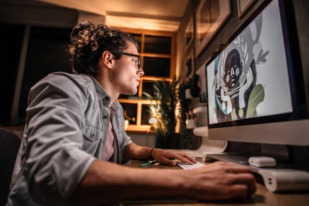 Working on creative ideas at night Young graphic designer working late night in his studio office. Sketching on paper and using computer for work. graphic designer stock pictures, royalty-free photos & images