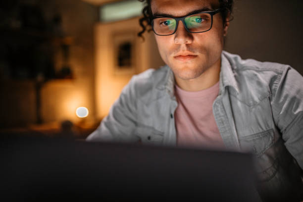 istock Young handsome man working late at night in his home office 1356061028