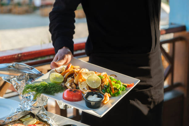 istock Waiter is holding plates with ready-made dish in his hand 1356062535