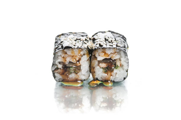 istock Two pieces of Maki sushi roll with Unagi eel isolated on white background with reflection 1356063463