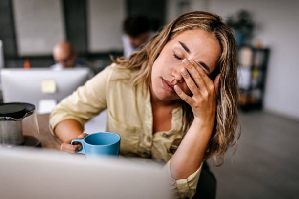 mujer de negocios cansada frotándose los ojos - stress at work fotografías e imágenes de stock