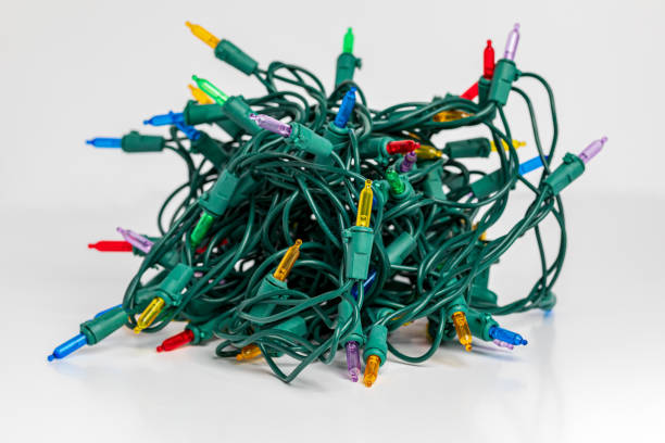 istock Tangled Christmas string lights isolated on white background. Holiday decoration safety and lighting concept. 1356073070