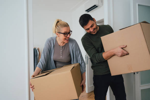 istock Man and Woman Carrying Boxes 1356074090