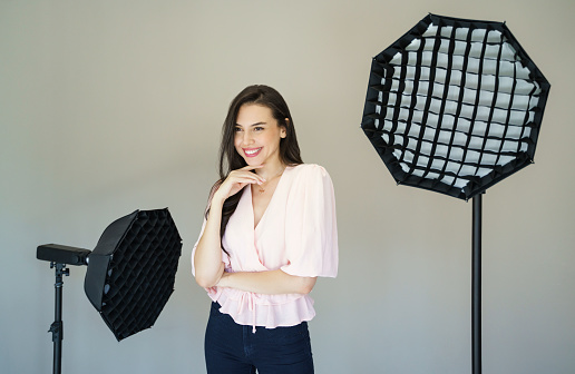 Close up portrait of a young beautiful model in a photo studio with a lighting equipment on the background