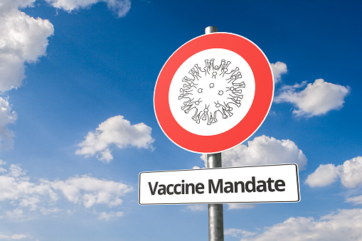 Vaccine mandate concept: Corona virus - Schematic image of a virus on a no entry road sign with the the text 