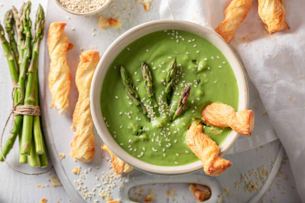 Green creamy asparagus soup as healthy and fresh appetizer.