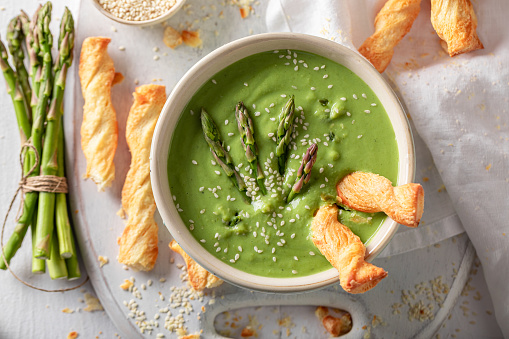 Green creamy asparagus soup as healthy and fresh appetizer. Veggie soup made of vegetables.