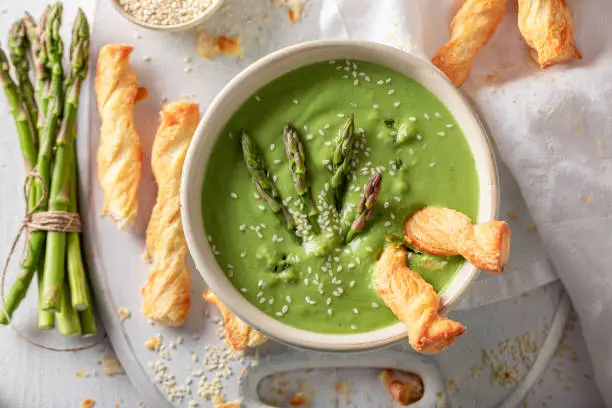 Photo of Green creamy asparagus soup as healthy and fresh appetizer.