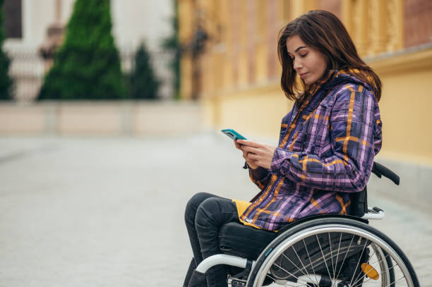istock Woman with disability using a smartphone while out in the city 1356079196