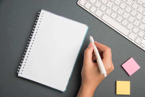 istock Keyboard Over A Table Beside A Notebook And Pens With Sticky Notes. Computer Keypad On Top Of A Desk With A Office Supplies And Desk Photo.. 1356079373
