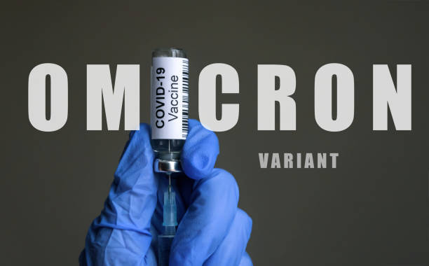 Omicron COVID-19 variant poster, vaccine bottle and syringe in doctor hands stock photo