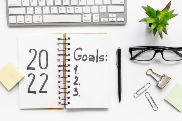 istock New year goals and resolutions concept. Hand writing text on notebook, top view 1356081494