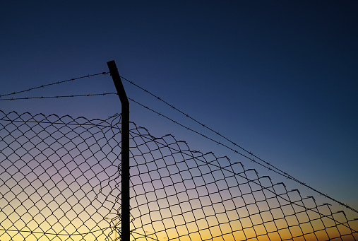 Barbed wire fence at sunrise, no people