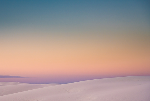 Ridges of Sand Dunes On The Horizon With Pastel Colors Fading Together At Sunset in New Mexico Park