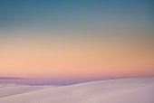 Ridges of Sand Dunes On The Horizon With Pastel Colors Fading Together At Sunset