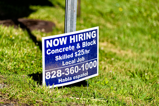 Banner Elk, USA - June 23, 2021: Banner Elk city small town village in North Carolina with sign phone number for now hiring during job shortage for skilled worker concrete and block construction