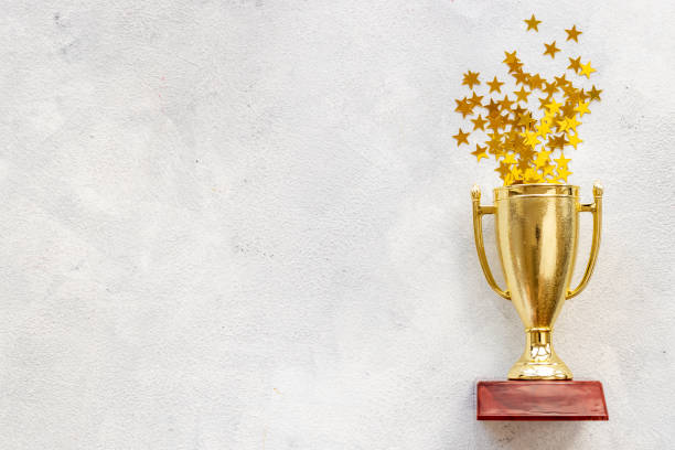 istock Victory concept with winner golden trophy cup and shiny stars 1356091712