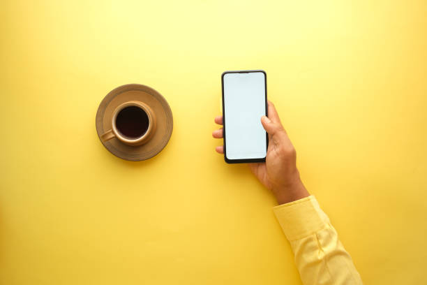 istock high angle view of me hand using smart phone and drinking coffee 1356091876