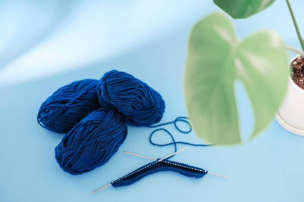 istock A blue skeins and knitting needles on light blue background. 1356094346