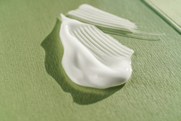 istock The texture of the white cream on a green background. 1356096776