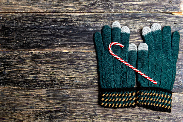istock Winter gloves and candy cane on wooden background 1356104739