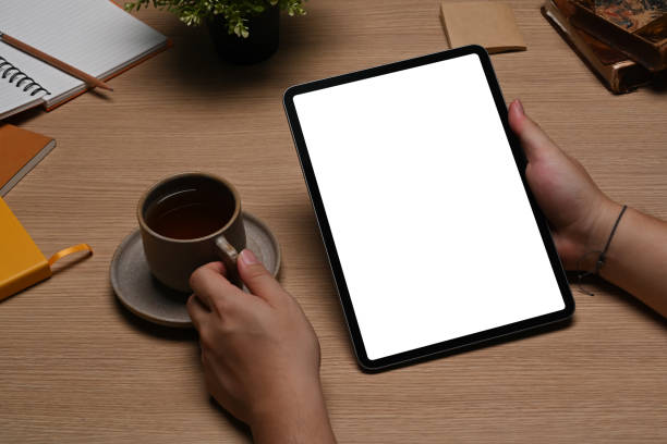 istock Close up view young man holding coffee cup and using digital tablet. 1356104816