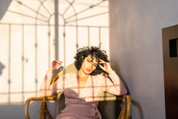 istock curly fashion latin model sitting relaxed on sofa looking at camera 1356108583