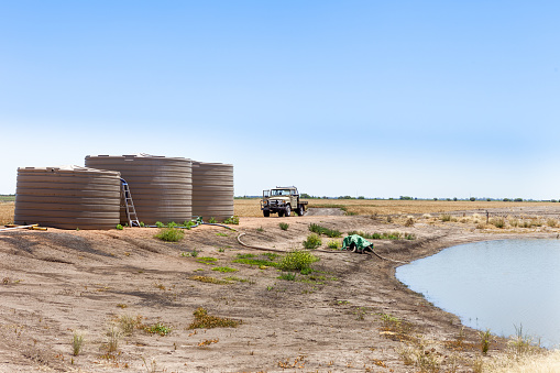 Moree, Australia - Nov 16, 2016: Water tanks near a dam on a grain farm in Moree, in northern New South Wales, Australia.Moree is a major agricultural area in this region.