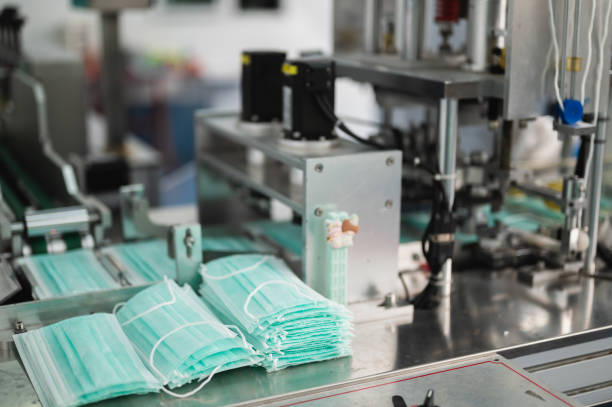 Both male and female Asian scientists are outfitted with protective gear. Examining the factory's machinery and materials used in the mask-making process. Covid 19 is a piece of preventive equipment. tanto los científicos asiáticos masculinos como femeninos están equipados con equipo de protección. examinar la maquinaria y los materiales de la fábrica utilizados en el proceso de fabricación de máscaras. el covid 19 es un equipo preventivo.