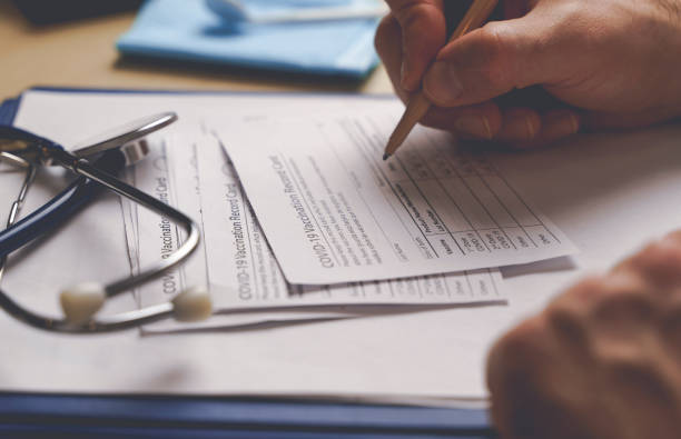 istock Vaccination record card. Vaccination form during the coronavirus epidemic on the doctor's table in the hospital. 1356118543