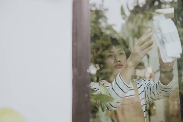istock Asain employee cleaning a front window-stock photo 1356122455
