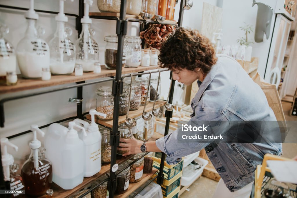 Asian man with zerowaste shopping concept-stock photo Zerowaste shopping concept of an Asian gay man while choosing and measuring food into container. Cleaning Product Stock Photo