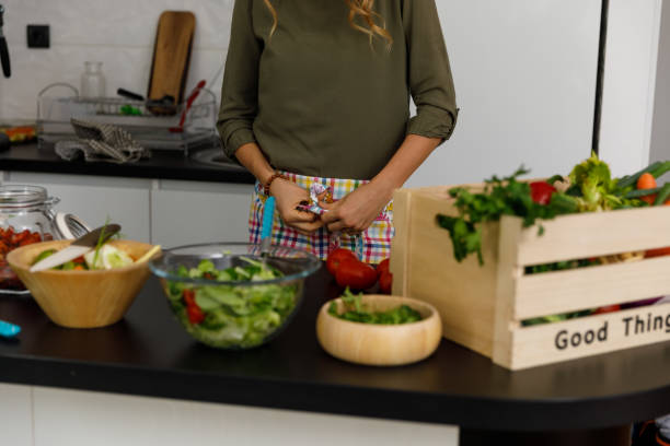 istock Unrecognizable woman tying a bow on a apron she is putting 1356123572