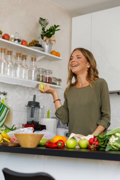 istock Cheerful woman holding an apple and smiling 1356123772