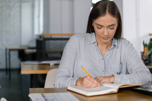 istock Young businesswoman writing ideas for a project she is working on 1356124043