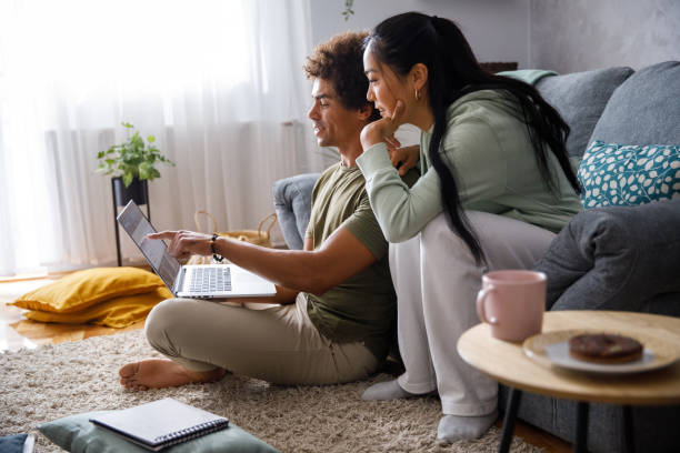 pareja millennial mirando sus finanzas a través de la banca en línea - home finances fotografías e imágenes de stock