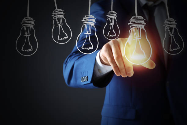 istock Idea concept. Businessman touching glowing light bulb on virtual screen, closeup 1356124658